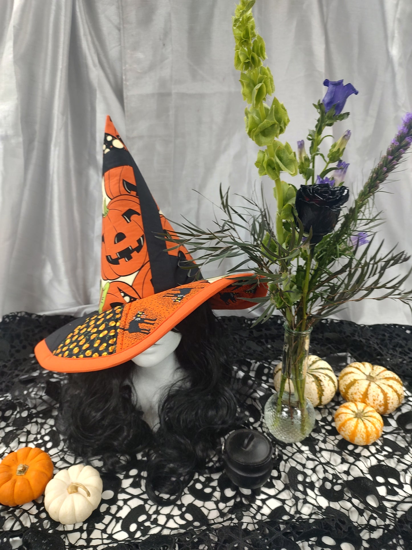 Local made withches hat with black rose vase arrangement